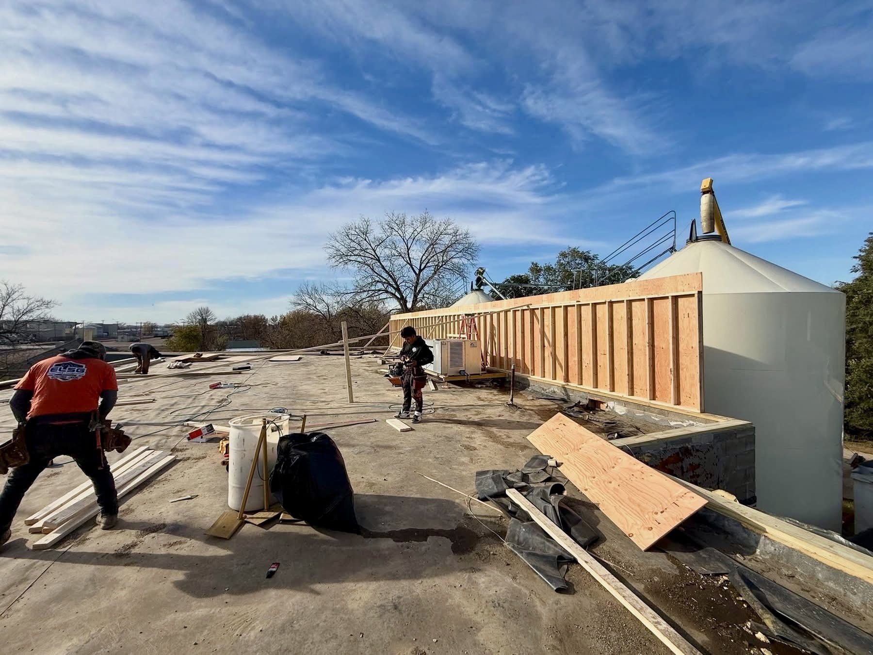 Our crew framing the parapet wall around the rooftop silo on a commercial low-slope roof.